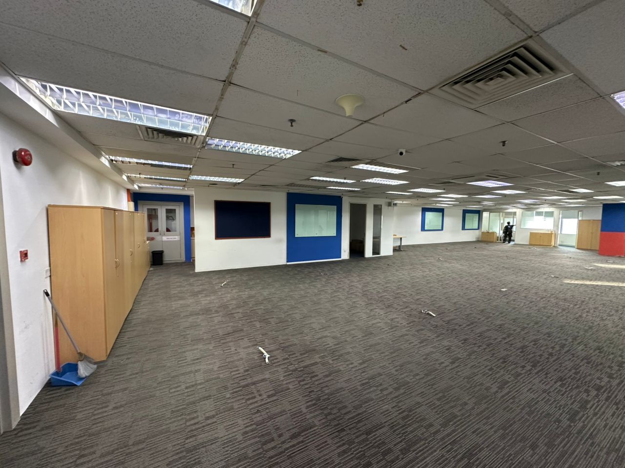 Carpeted open-plan office with partitioned rooms and timber cabinets at Plaza Sentral, KL Sentral.