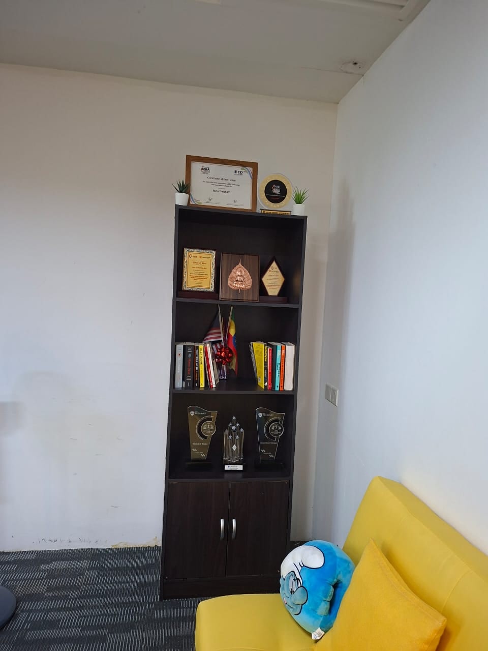 Lounge corner with shelving and yellow seating in Plaza Sentral office for rent, KL Sentral