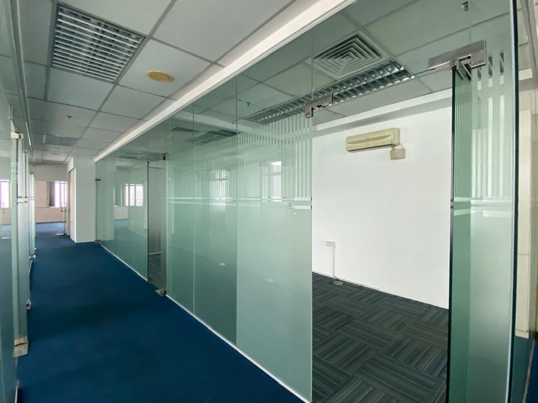 Carpeted corridor beside glass-partitioned rooms in a fitted Plaza Sentral office for rent in KL Sentral.